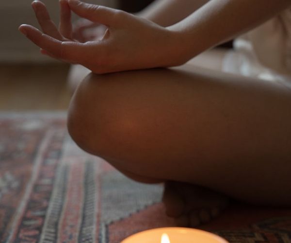 Person meditatively sitting in a cozy room